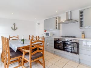 a kitchen with a table and chairs and a stove at Jib Sail-18148 in Wroxham