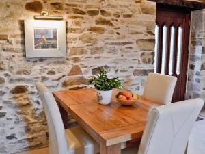 a wooden table with chairs and a bowl of fruit on it at Penno Cottage - 24440 in Bodmin