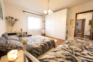 een slaapkamer met 2 bedden en een dressoir bij B&B Le Tre Grazie in San Martino di Lupari