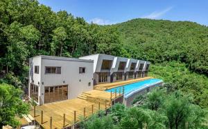 a house with a swimming pool in the middle of a hill at Tongyeong Amusing Story in Tongyeong