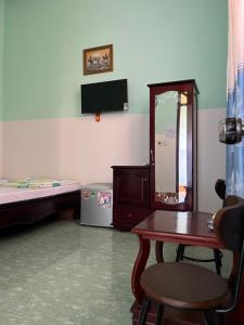 a room with a bed and a table and a mirror at Hotel Minh Vy in Long Hai