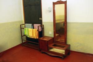 a bathroom with a mirror and a shelf with towels at Sumith Villa in Weligama