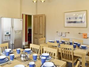 a dining room with a table and chairs and a refrigerator at The Limes in Swanwick