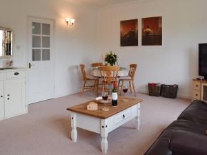 a living room with a coffee table and a kitchen at Little Longmead in Findon