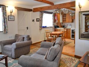 a living room with two couches and a table at Gingerbread Cottage in Fairford
