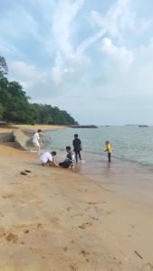 een groep mensen die op het strand spelen bij Mutiara Chalet in Melaka