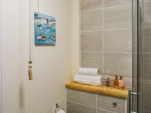 a bathroom with a shower stall and a wooden counter at Honeysuckle Cottage in Cury