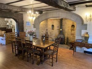 a dining room with a table and a fireplace at Inglenook Cottage in Kettlewell