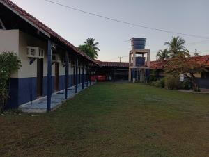 a building with a water tower next to a yard at Pousada Village Maçarico in Salinópolis