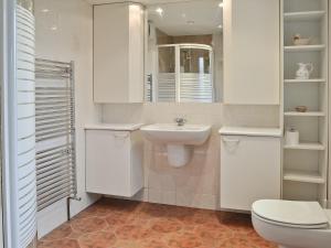 a white bathroom with a toilet and a sink at The Waiting Rooms in Gaisgill