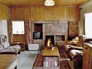 a living room with a couch and a fireplace at Glentairre Cottage - Swww in Balnaboth