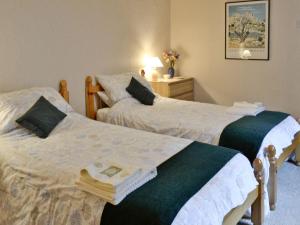 two beds sitting next to each other in a room at Calton Cottage in Kettlewell