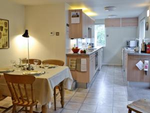 a kitchen with a table and chairs and a kitchen with a table and a table at Calton Cottage in Kettlewell