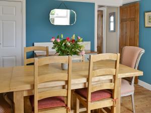 a dining room with a wooden table and chairs at Sea Folly in Brightlingsea