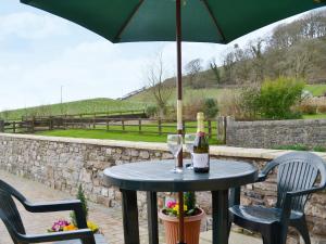 a table with an umbrella and two glasses of wine at The Smithy - Op6 in Carmarthen