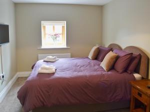 Un dormitorio con una cama morada con toallas. en The Granary en Pendleton