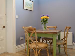a dining room table with chairs and a vase of flowers at Bag End in Keswick