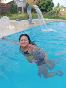 a woman in a swimming pool with a fountain at Pousada Village Maçarico in Salinópolis