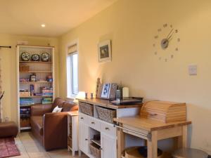 Ardura Cottage في Lochdon: غرفة معيشة مع طاولة وأريكة
