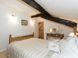 1 dormitorio con cama y mesa con espejos en Rowlandson Ground Cottage, en High Yewdale