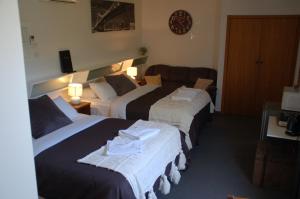 a hotel room with two beds and a couch at Calder Motel in Bendigo