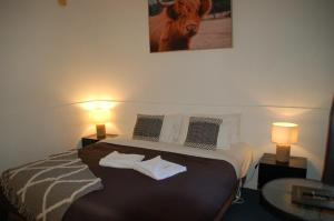 a hotel room with a bed with two lamps on it at Calder Motel in Bendigo