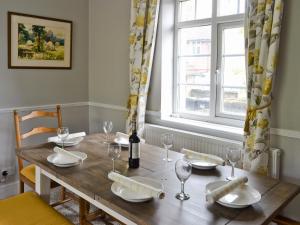 a dining room table with a bottle of wine on it at Dove Cottage in Great Rowsley