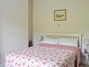a bedroom with a bed with a red and white blanket at Dove Cottage in Great Rowsley