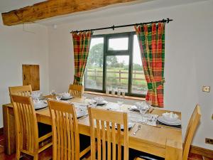 uma sala de jantar com uma mesa e cadeiras e uma janela em Tomfield Cottage em Kingsley