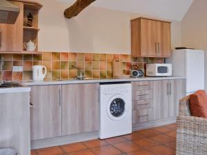 a kitchen with a washing machine and a microwave at Dill - E4324a in Ludham