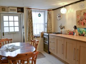 een keuken met een houten tafel en een tafel en een eetkamer bij Pebbles in Lympstone