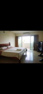 a bedroom with a large bed and a window at We Residence Studio in Pattaya Central