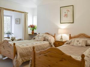 a bedroom with two beds and a dog sitting between them at Osprey Cottage in Dunkeld