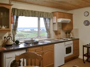 a kitchen with a sink and a window at Gallt Y Balch in Llangadwaladr
