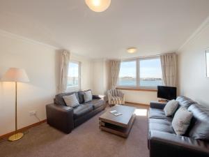 a living room with two couches and a tv at No 5 Esplanade Court in Oban