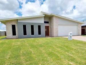 a house with a lawn in front of it at Large and Private Executive Home - Secure parking for boats in Hervey Bay