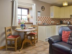 une cuisine avec une petite table et des chaises dans l'établissement The Cottage - Osd, à Penbryn