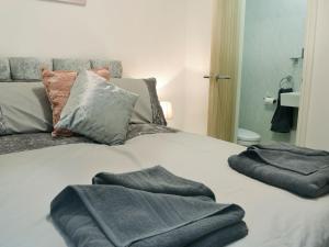 a bed with two towels on top of it at Hidden Gem Cottage in Great Driffield