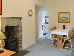 a living room with a table and a fireplace at Scafell Apartment in Ambleside