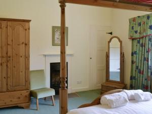 a bedroom with a bed and a mirror and a chair at Scafell Apartment in Ambleside