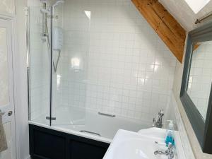 een badkamer met een douche, een wastafel en een bad bij The Old Post Office - 27967 in Chedworth