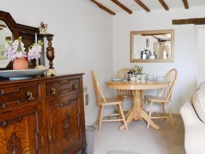 een eetkamer met een tafel en een houten dressoir bij The Old Post Office - 27967 in Chedworth