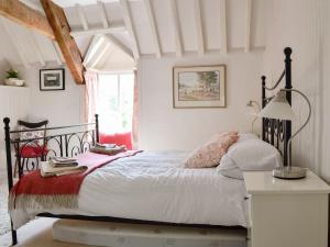 a bedroom with a large bed and a table at The Old Post Office - 27967 in Chedworth