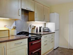 Clachan的住宿－Seabank Cottage，厨房配有炉灶和冰箱。
