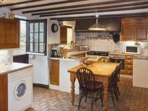una cocina con mesa de madera y sillas. en Churchview House, en Winterborne Abbas
