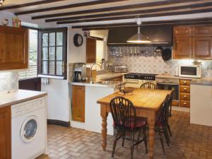 Il comprend une cuisine avec une table et des chaises en bois. dans l'établissement Churchview House, à Winterborne Abbas