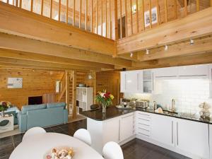 a kitchen with white cabinets and wooden ceilings at Hillview in Little Petherick