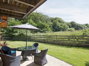 a table and chairs with an umbrella on a patio at Hillview in Little Petherick