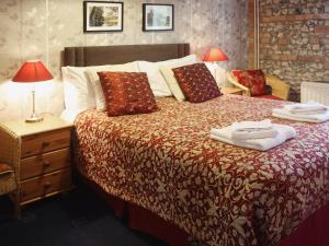 1 dormitorio con 1 cama con toallas en Churchview House, en Winterborne Abbas