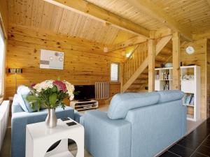 a living room with two blue chairs and a tv at Hillview in Little Petherick